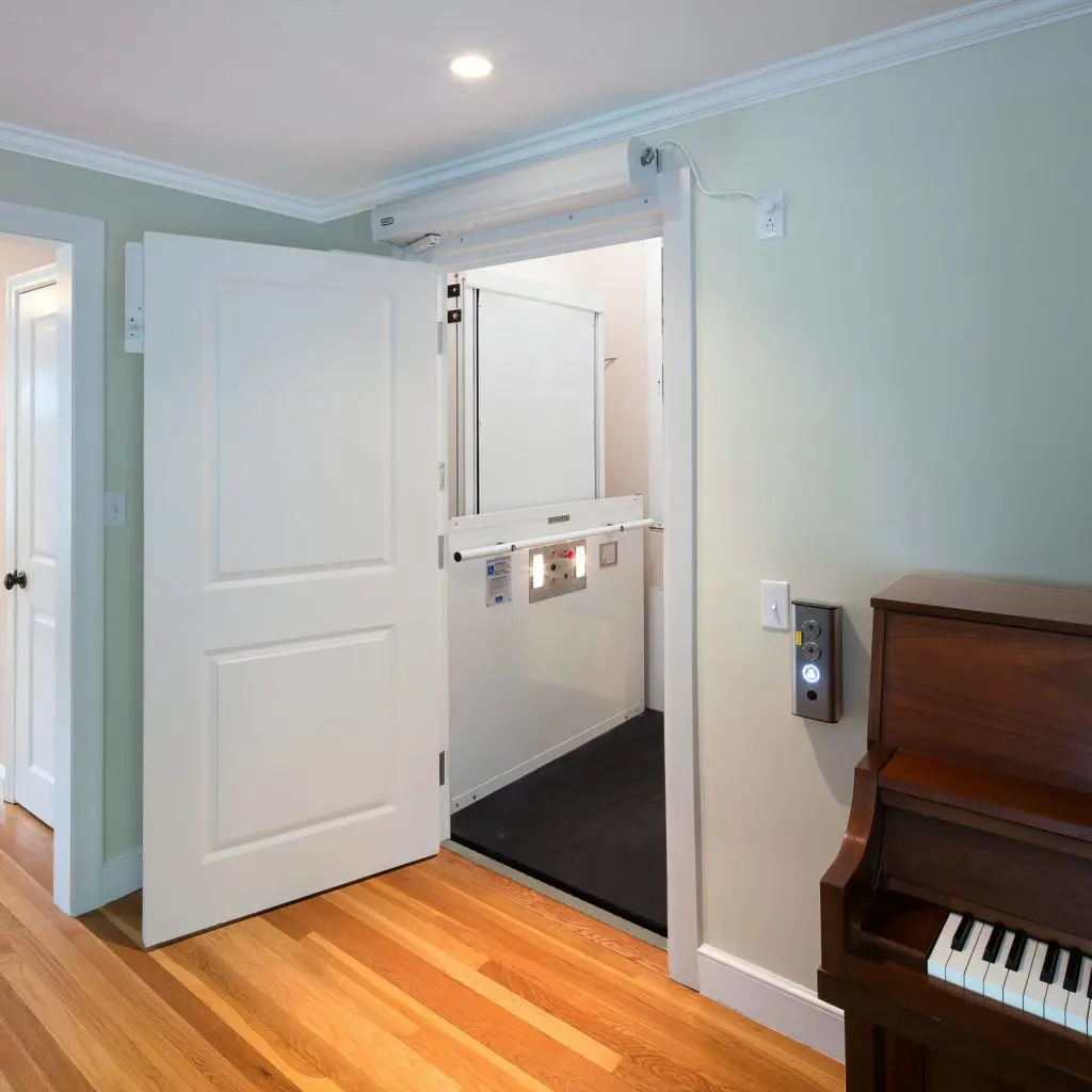 interior view of a lift behind a door, next to a piano