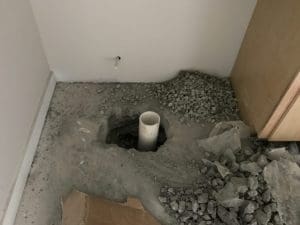 toilet core hole and waste pipe in unfinished cement floor