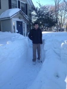 Max with cane between snow banks.